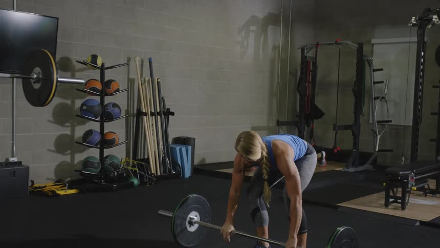 Men and women lift weights in a gym