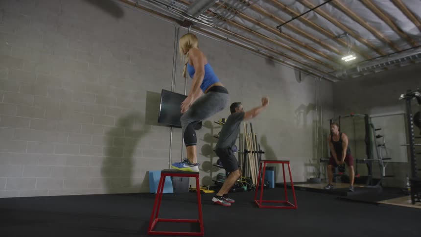 A muscular woman and two men work out in the gym
