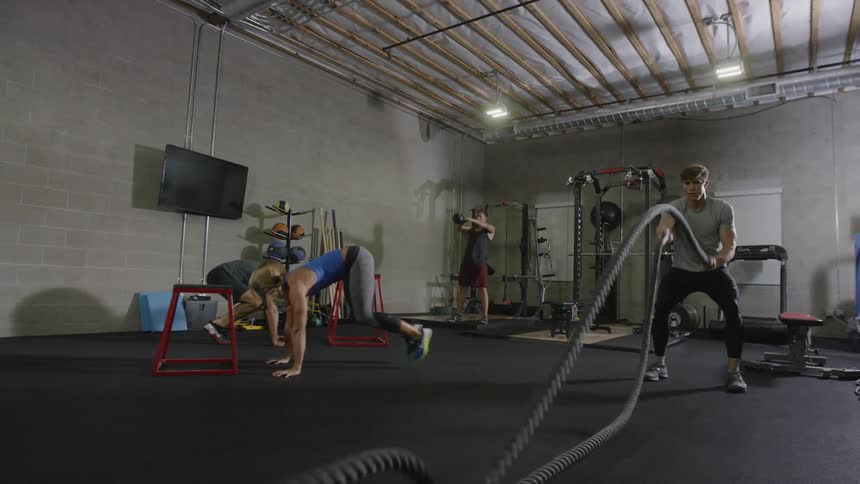 A muscular woman and three men work out in the gym