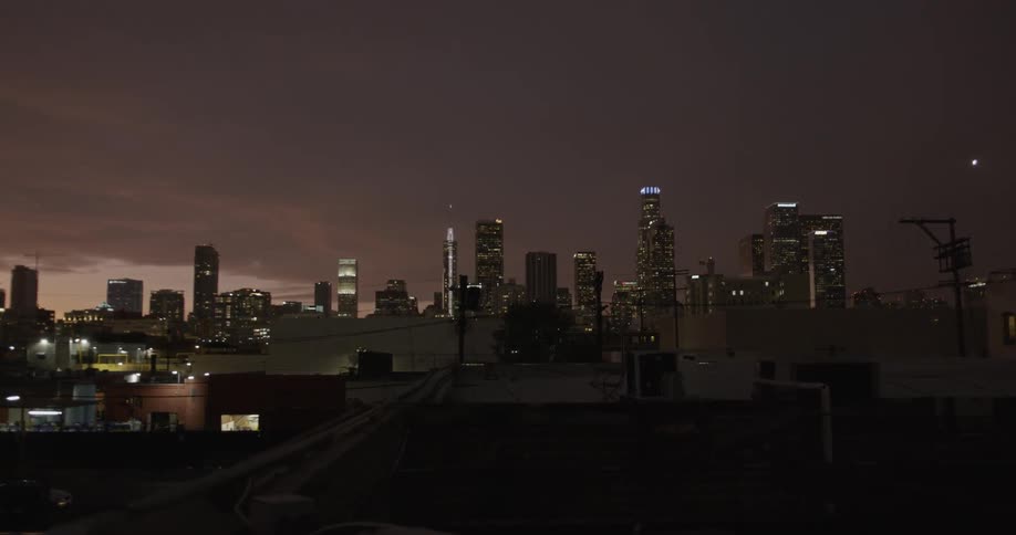 Car drives along road near downtown at night