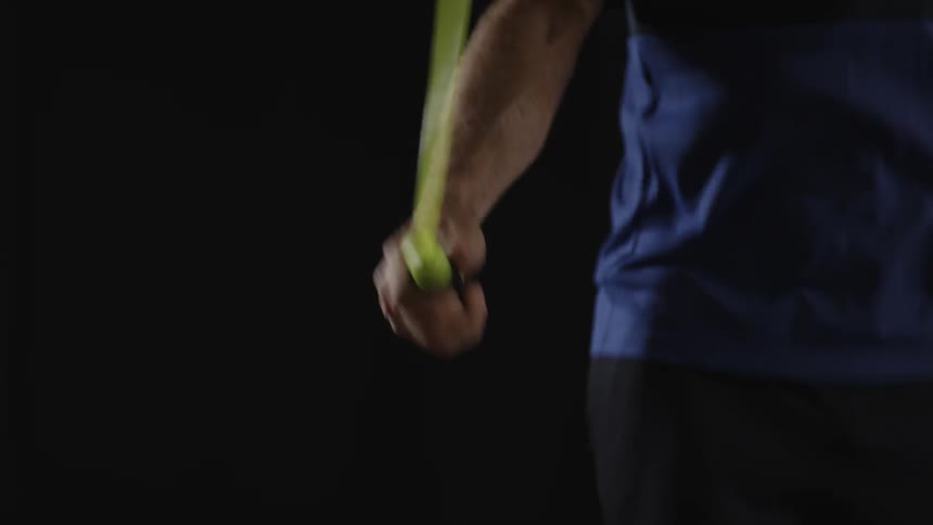 Man jumps yellow rope on a black background