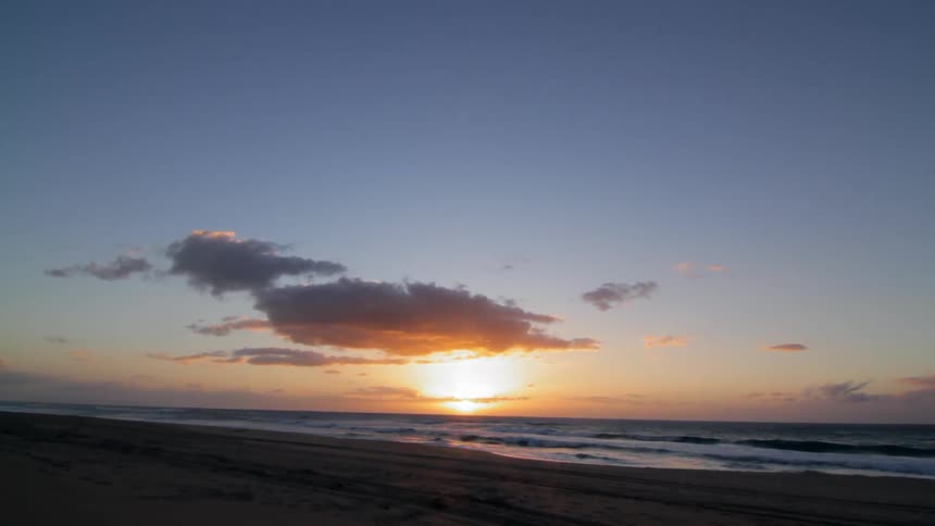 Ocean waves wash ashore at sunset