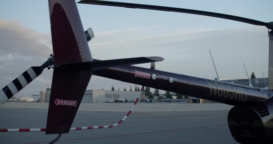 A large helicopter sits on a runway on a cloudy day