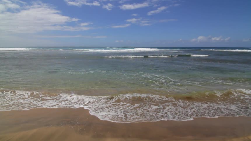Ocean waves wash ashore a sandy beach
