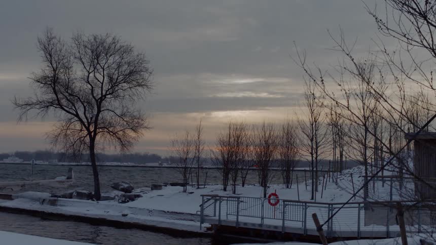 A view of the water behind snow covered land