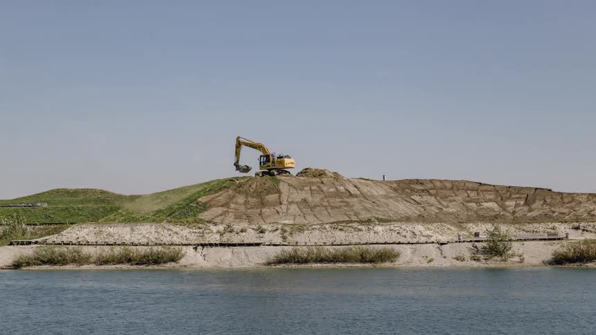 A construction vehicle is moving dirt around on a hill