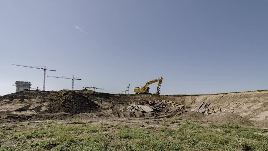 A backhoe is moving dirt around at a construction site