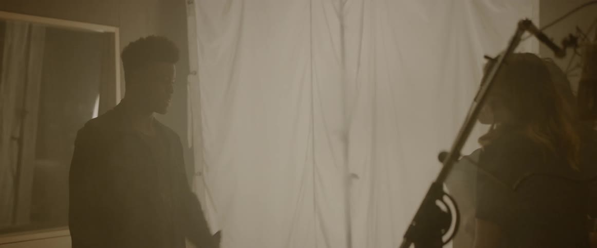 A man is talking to a woman in a dimly lit room