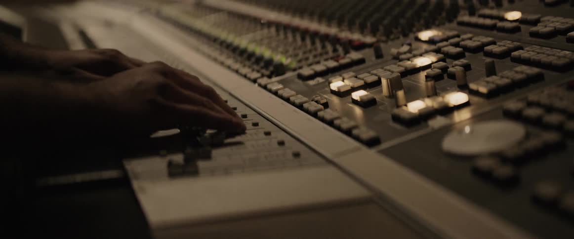 A man adjusts the controls on an analogue desk
