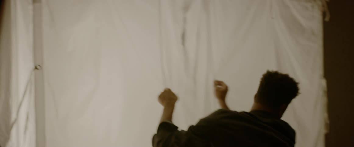 A man sets up a white sheet around a light for a photography shoot