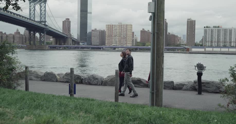 Man and woman walk along on the promenade looking around during daylight