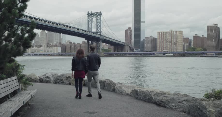 Man and woman are walking outdoors by the coast