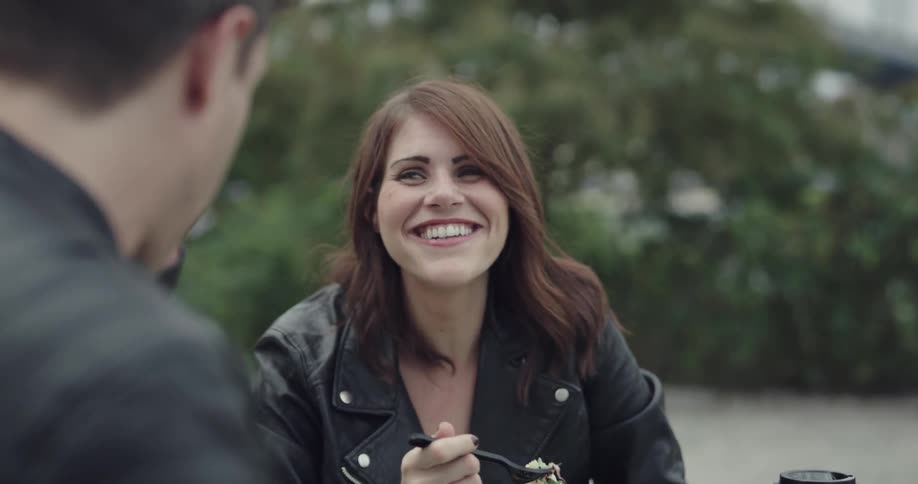 Woman smiles and nods her head while talking to a man