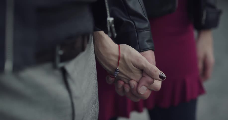 A man and woman hold hands