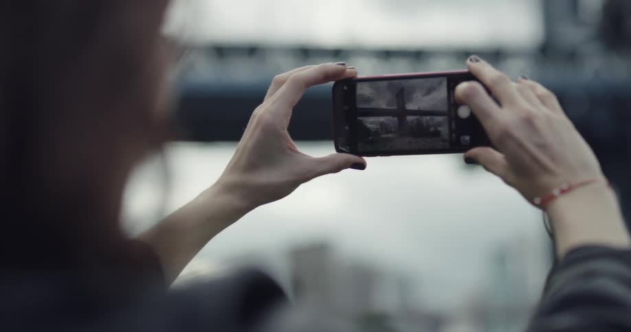 A woman is taking a video on a smart phone
