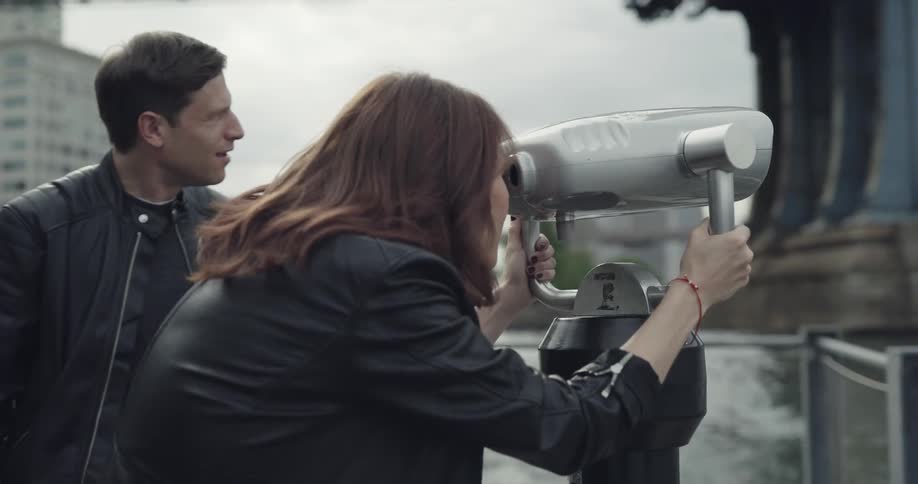 A woman uses a viewfinder to look over a city