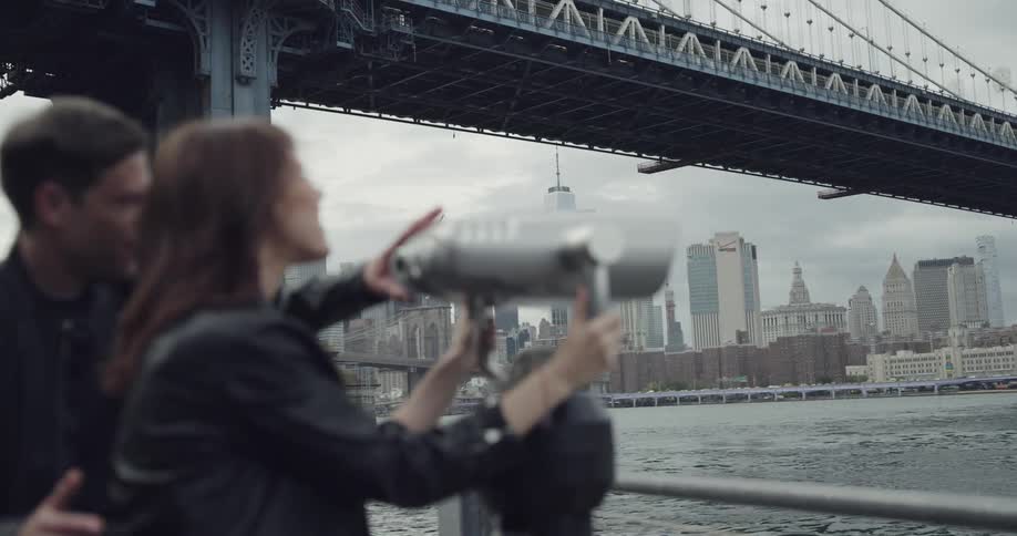 Woman looks trough the binoculars at the public park