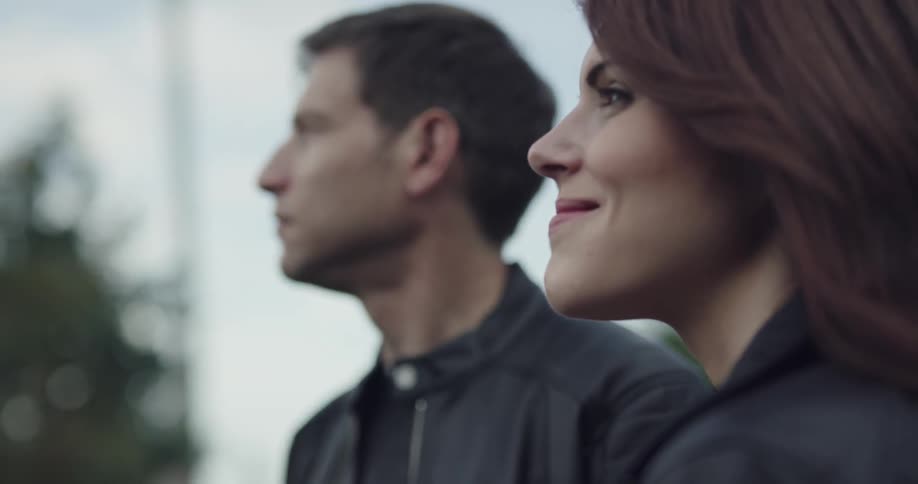 A man and woman stand together outside