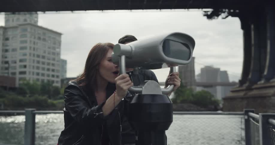Woman see trough a telescope on the park