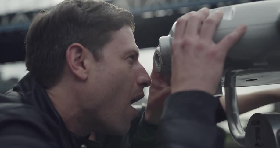 A man and woman gaze through some binoculars