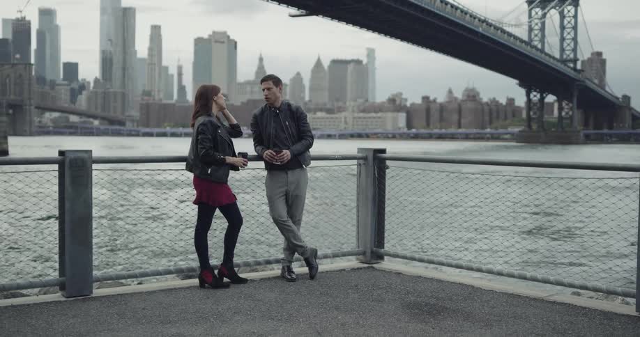 Couple talks near the river under brooklyn bridge