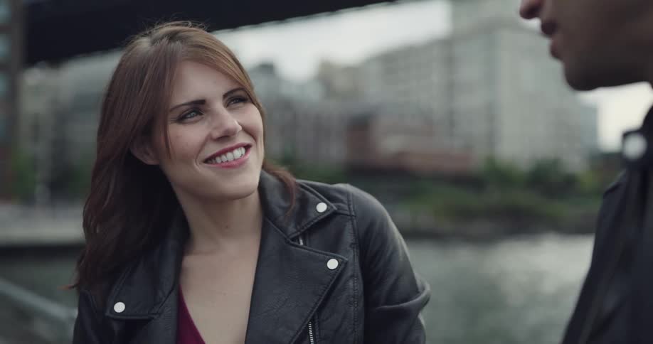 A woman is talking with a man by the city