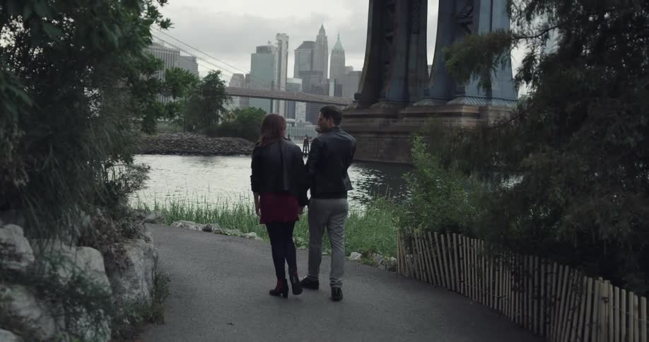 Couple walks in the public park near the river