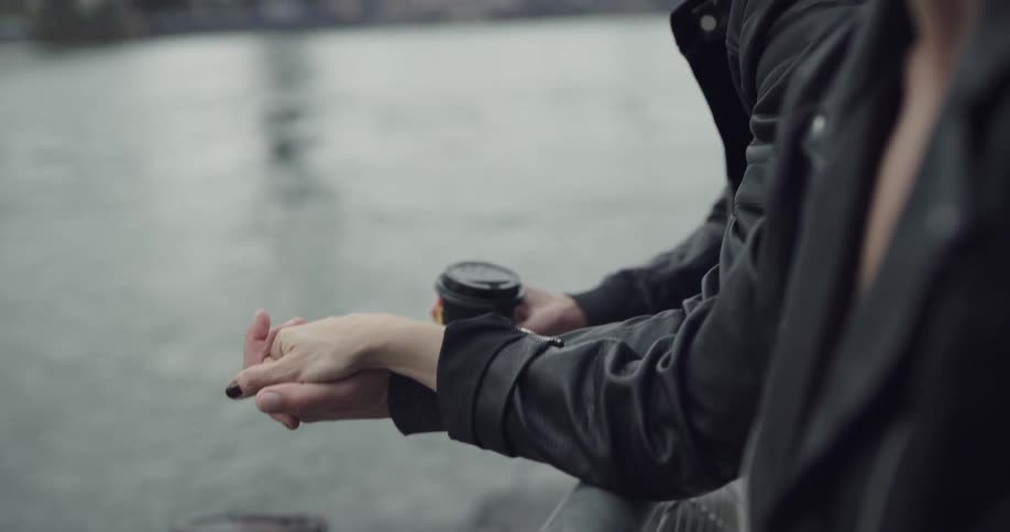 Man and woman hold hands and coffee cups