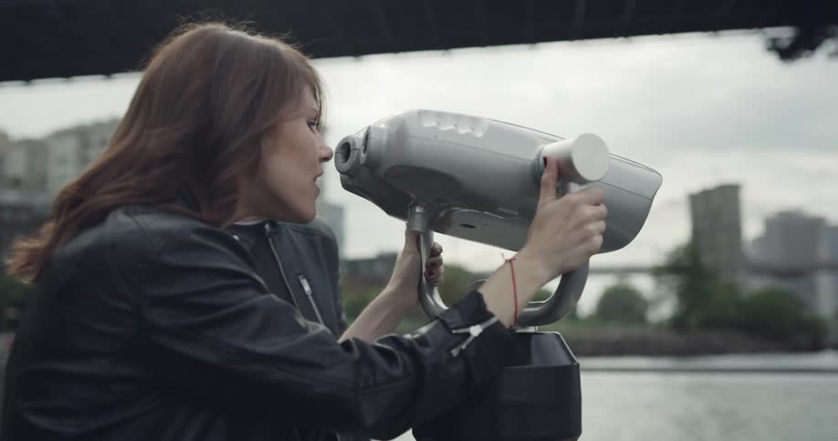 Man and woman use coin operated binoculars