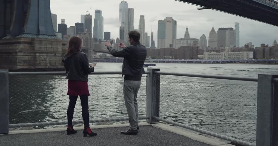 Man and woman takes picture of bridge tower support