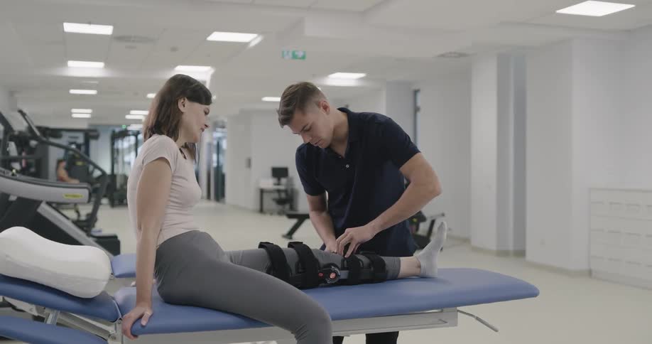 A man is helping a woman stretch her leg