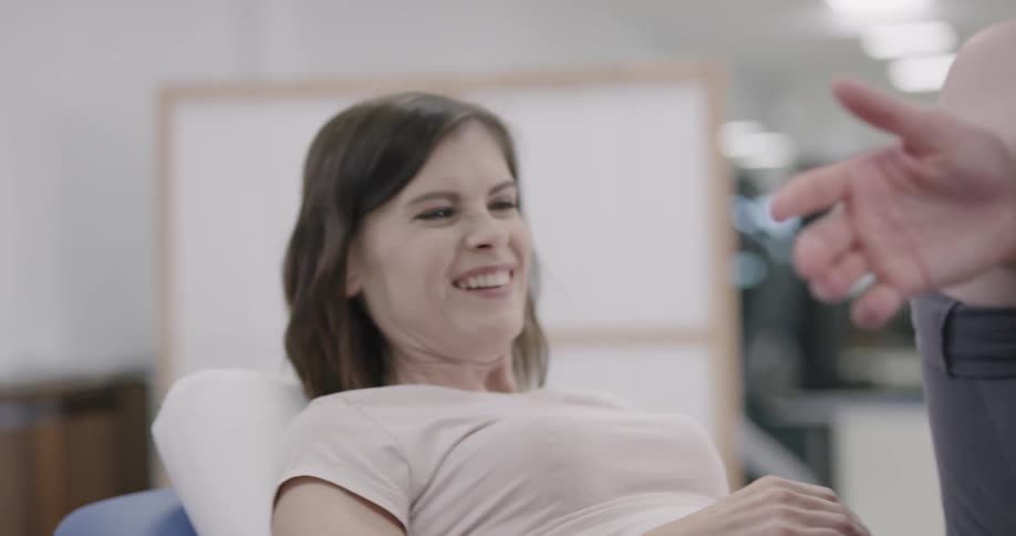 A young man performs physical therapy on a woman