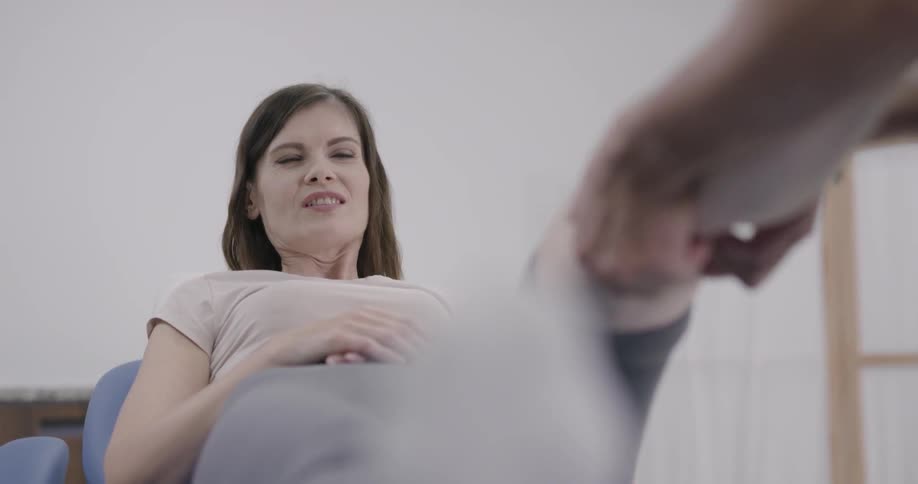 A physical therapist works on a womans leg and knee