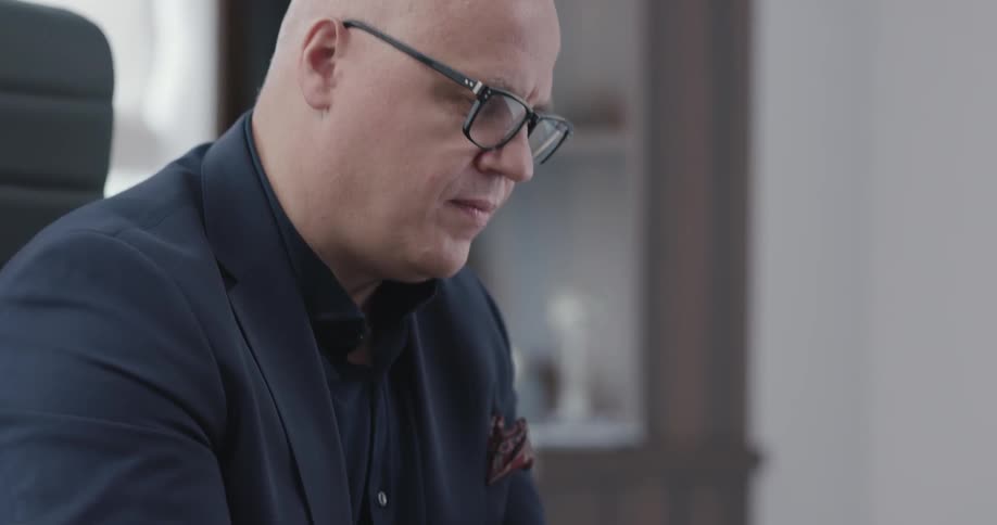 Man sitting at the table uses tablet in the office during daylight