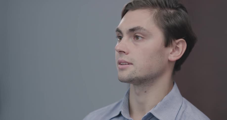 Man nods his head as he listens to someone talking to him