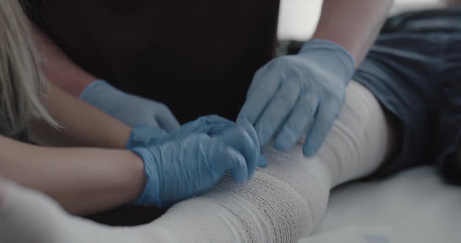 Medical professionals wrap patients leg in bandages