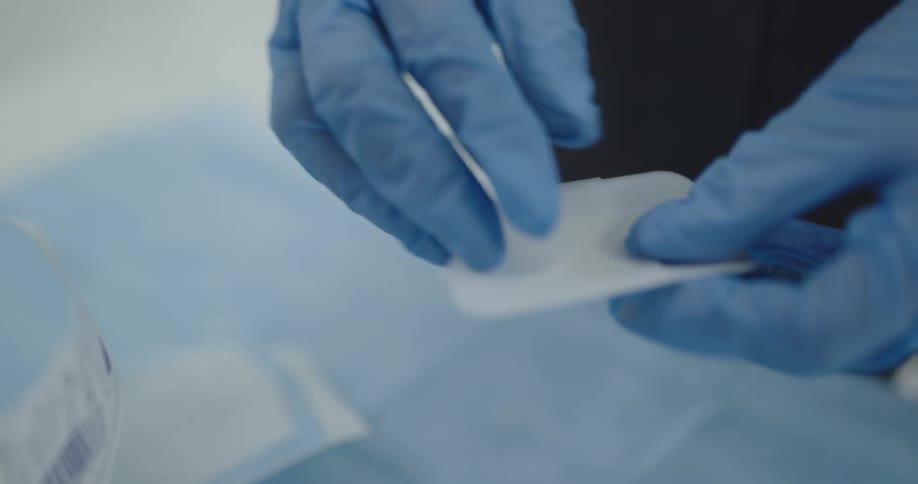 Doctor opening a plaster pack with a latex gloves