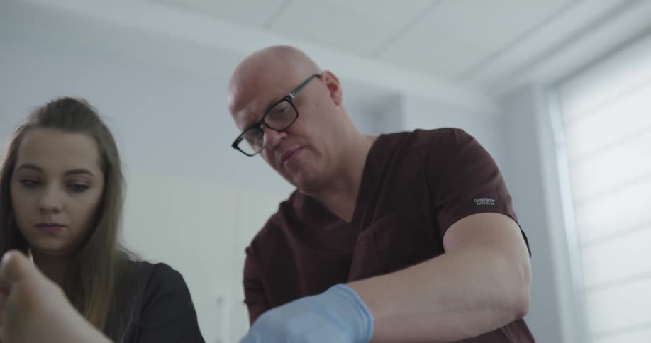Male doctor examining something on the patient at the room