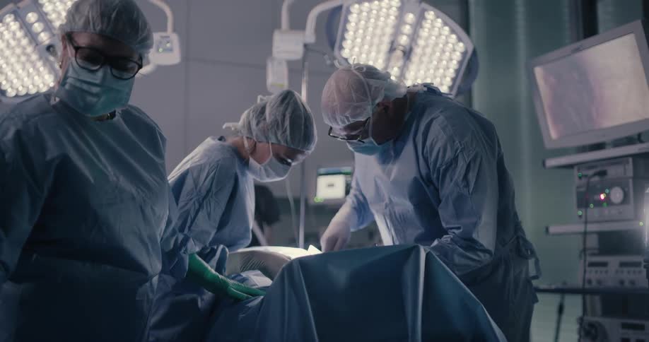 Three people work on a patient