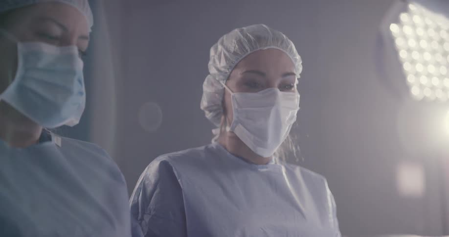 Doctors and nurses work on a patient in a surgical theater