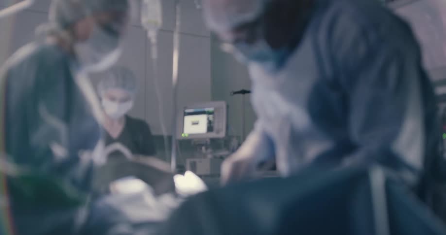 Surgeons and nurses work on a patient in an operating room