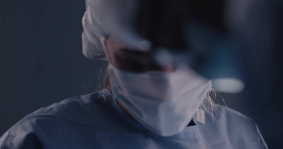 Medical professionals work on a patient under bright lights