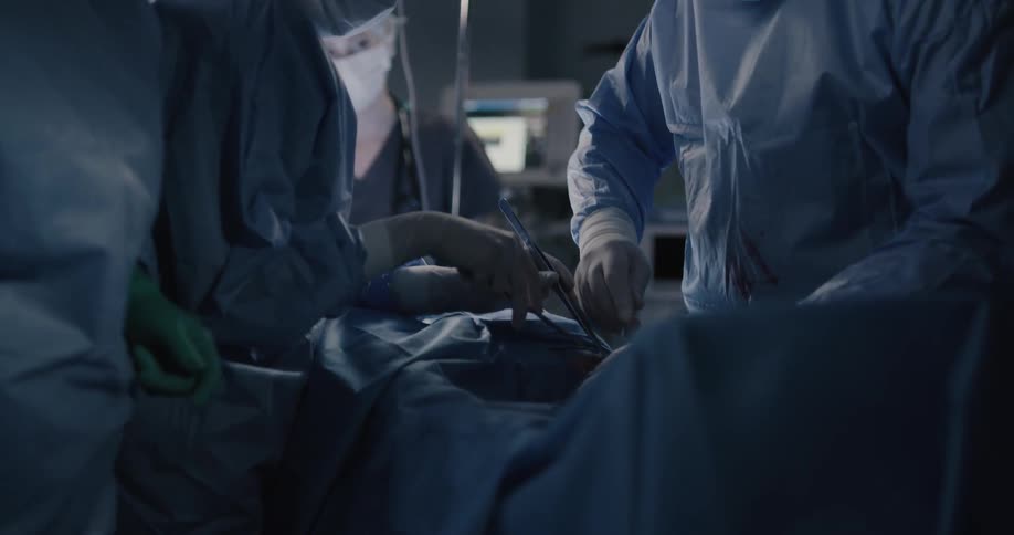 Doctors and nurses work on a patient in an operating room