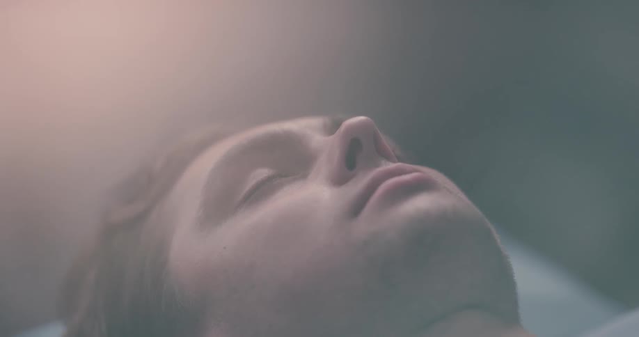 A person sleeps with a light shining on them