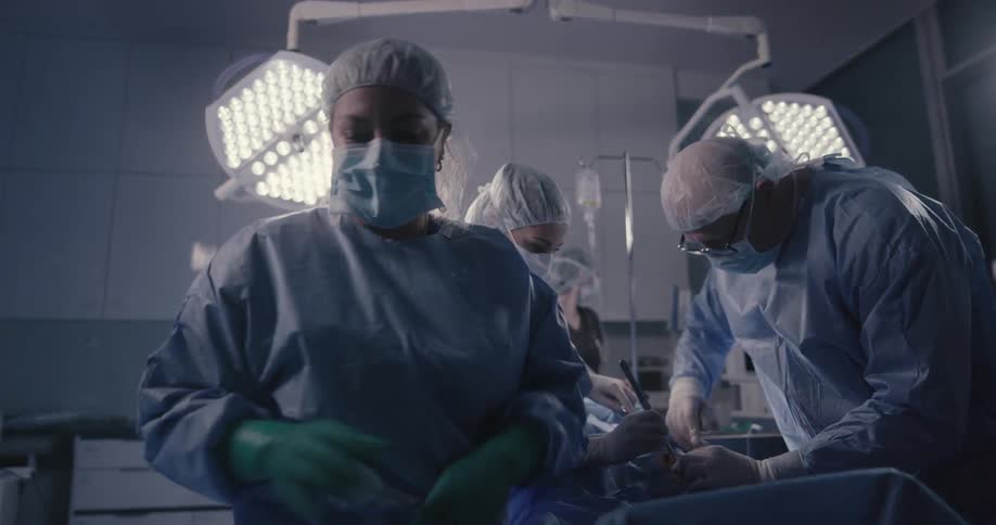 A patient lies on a table as doctors and nurses work on them