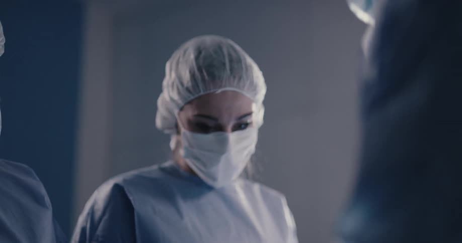 People are in a room performing surgery