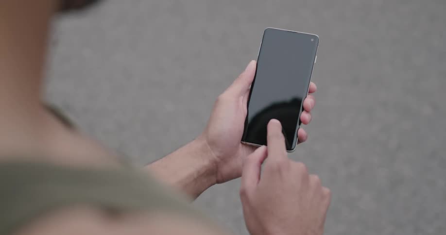 Black man uses smartphone during daylight