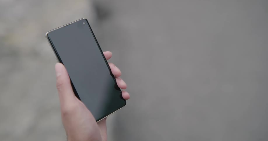 Woman holds smart phone during daylight