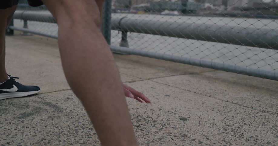 A man is stretching near the water
