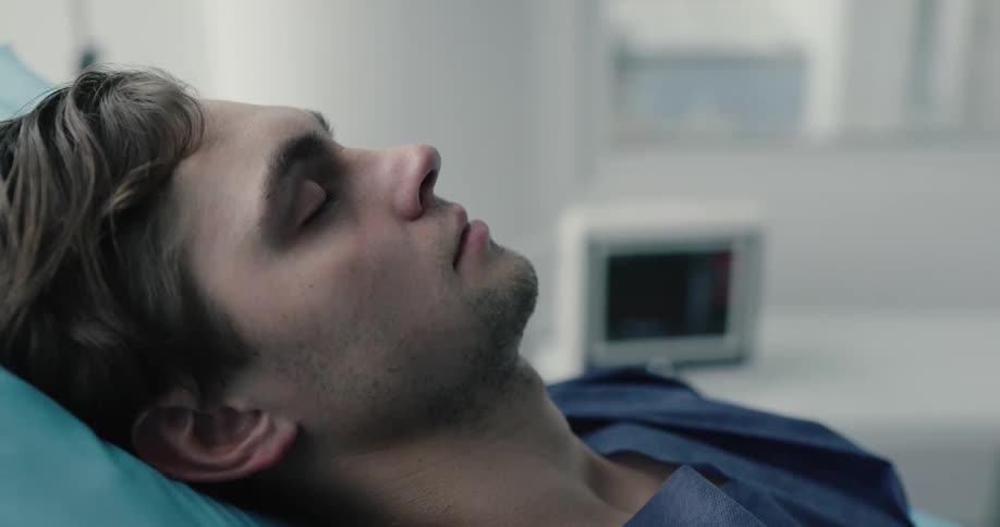 A patient closes his eyes and sleeps in a hospital room